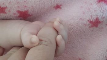Finger in der Hand von Neugeborenem